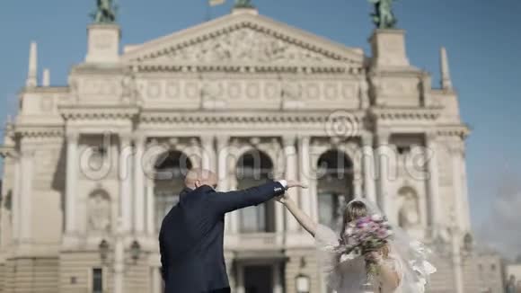 新婚夫妇在老城的中心跳舞新郎新娘婚礼视频的预览图