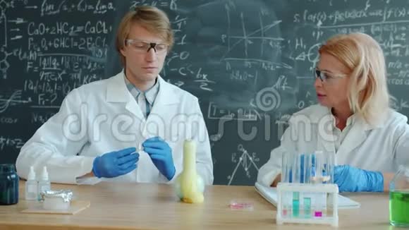 快乐的男人和女人在实验室的化学测试中做着击掌和竖起大拇指视频的预览图