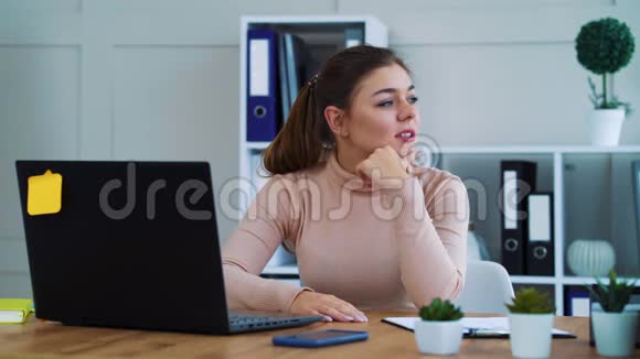 伤心的女孩在现代办公室的笔记本电脑上打字视频的预览图