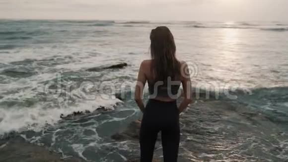 海洋海滩上的女孩剪影张开双臂背景是日落视频的预览图
