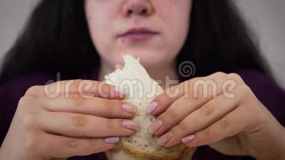 极度特写的肥胖白人黑发女人咀嚼三明治年轻的胖女孩吃不健康的食物肥胖视频的预览图
