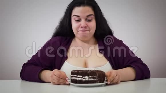 镜头接近丰满的白人女人享受巧克力蛋糕然后走开快乐的少女视频的预览图