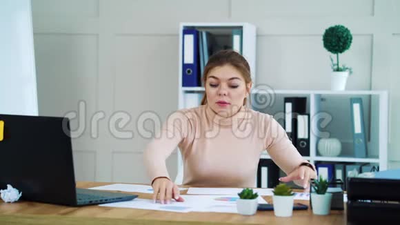 办公室女孩在桌面文件中寻找必要的图表视频的预览图