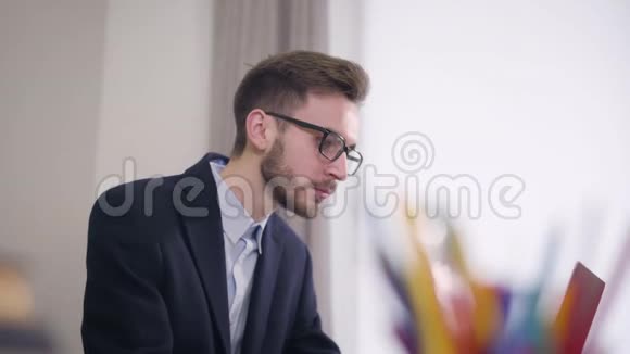 从侧面看年轻英俊的白种人戴着眼镜的男子坐在桌子旁就像一个可爱的非裔美国女孩走过来视频的预览图
