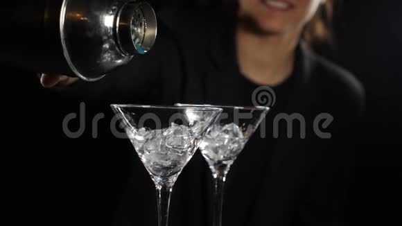 女调酒师准备亮蓝色鸡尾酒从摇床上倒出液体用冰做酒精鸡尾酒视频的预览图