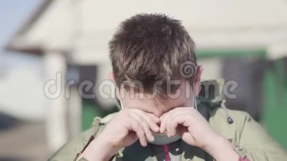 病态白人小男孩戴着面具揉眼睛打喷嚏的肖像在户外摆姿势的生病儿童视频的预览图