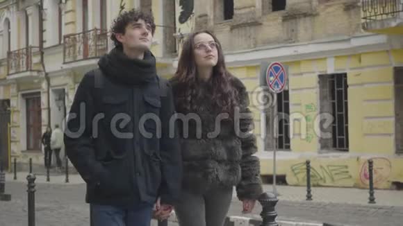 快乐的白种人夫妇在城市大街上散步聊天的肖像积极的男孩和女孩旅行城市视频的预览图