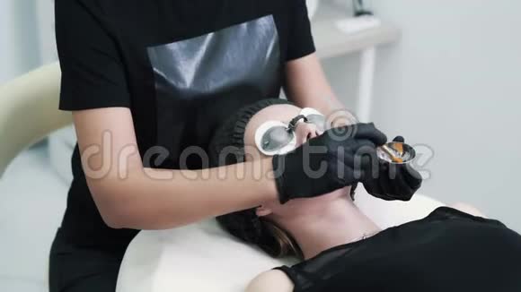 特写美容师将黑碳面膜敷于女性面部肌肤视频的预览图