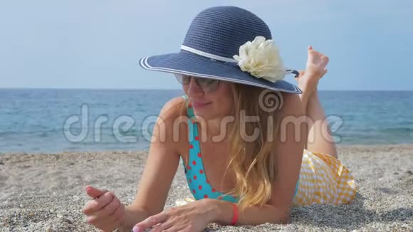 戴着墨镜和帽子的女性游客在海边视频的预览图