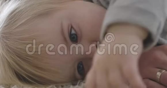 极度美丽的白人女婴躺在床上的特写肖像平静迷人的孩子休息的肖像视频的预览图