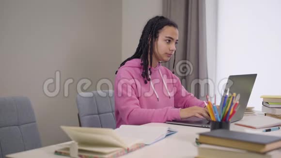 侧视自信迷人的非裔美国女孩打字在笔记本电脑键盘上因为她的男性伴侣来了青年视频的预览图