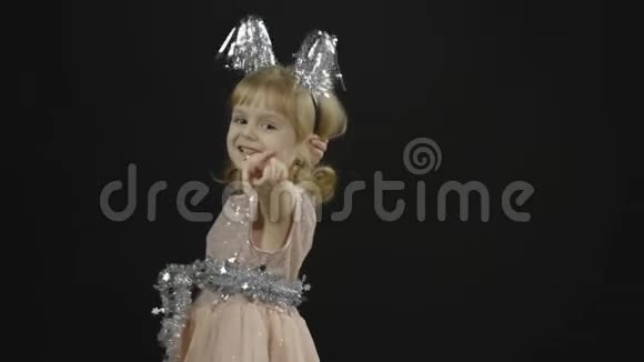 快乐美丽的小女婴穿着光滑的裙子圣诞节做鬼脸视频的预览图