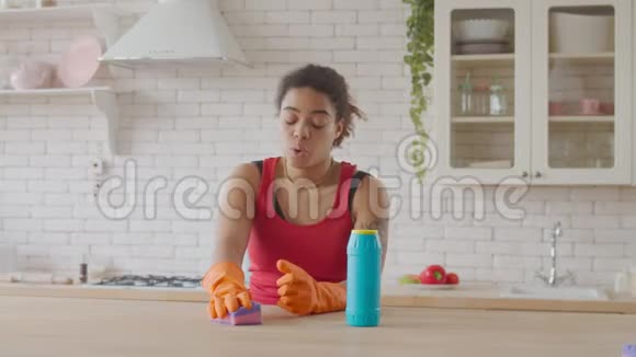 疲惫的女人用清洁剂擦桌子视频的预览图