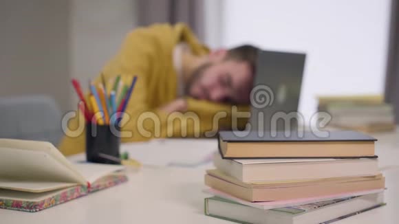 年轻的高加索男学生醒来开始在笔记本电脑键盘上打字累了英俊的男孩工作过度重点视频的预览图