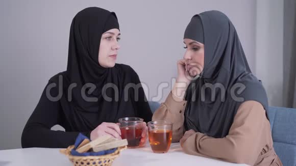 戴着头巾的温和的穆斯林女人安抚了她现代的女性朋友年轻女士安慰和拥抱哭泣视频的预览图