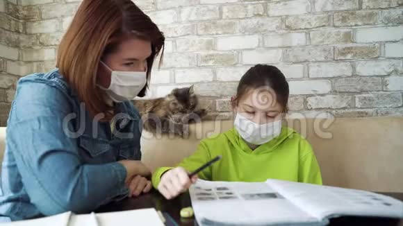 母亲和女儿在检疫期间戴着医用口罩和做作业视频的预览图