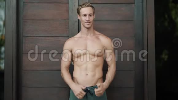 肖像赤膊男子肌肉发达显示拇指标志木头背景视频的预览图