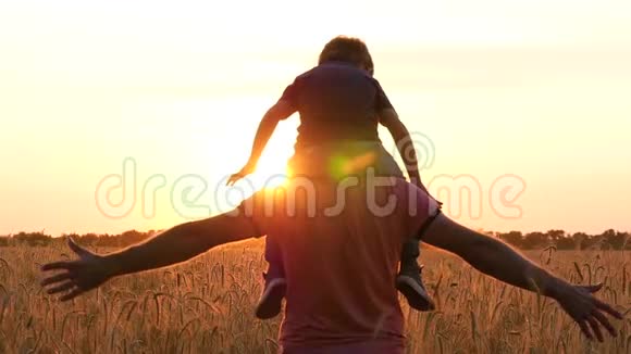 父亲抱着儿子肩膀模仿飞机的飞行日落时分幸福家庭的剪影视频的预览图
