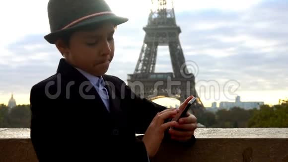 男孩看着埃菲尔铁塔旁边的电话视频的预览图