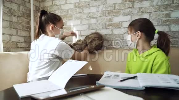 女孩子戴着医疗面具玩猫猫而不是学习视频的预览图