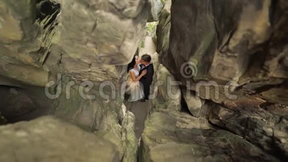 新郎新娘站在山上的山洞里新婚夫妇相爱视频的预览图