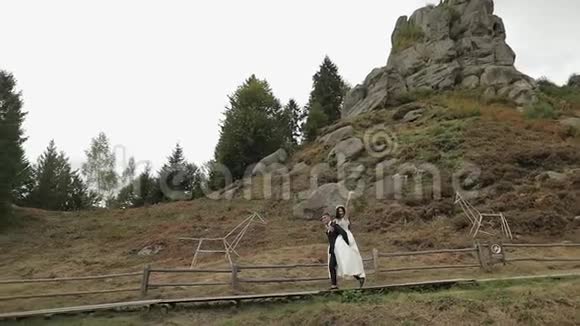 新郎新娘在山上散步新婚夫妇相爱视频的预览图