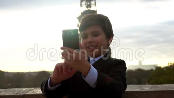 男孩正在和埃菲尔铁塔拍自拍照片视频的预览图