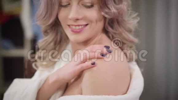 性感的白种人女人在肩膀上涂上奶油和微笑的肖像在家照顾自己身体的年轻女孩视频的预览图