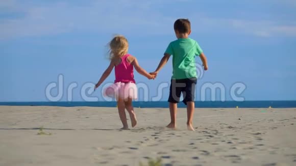 在海滩上散步的男孩和女孩的后景视频的预览图