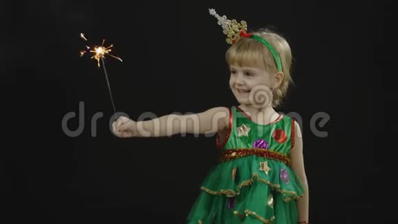 穿着圣诞树装的快乐美丽的女婴燃烧的孟加拉灯视频的预览图