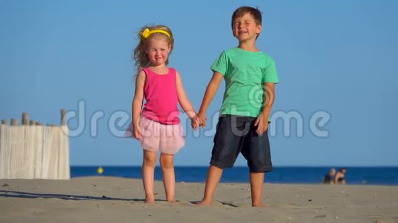 小男孩和小女孩在沙滩上玩耍视频的预览图