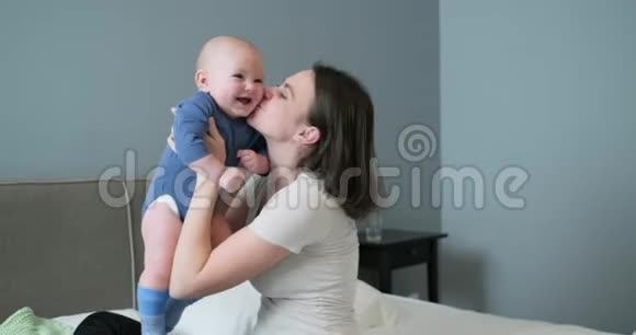 照顾婴儿母亲抱着孩子拥抱亲吻视频的预览图