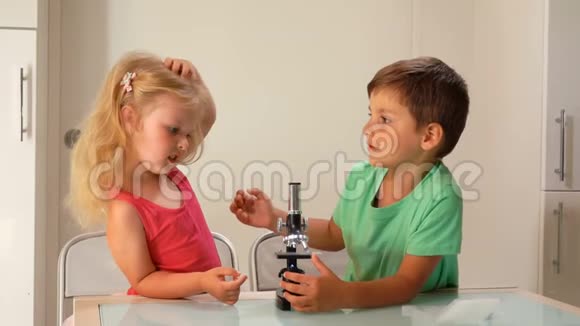 男孩教女孩如何通过显微镜观察视频的预览图