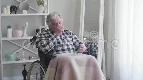成熟的白种人白发老人坐在轮椅上头痛得厉害老年视频的预览图