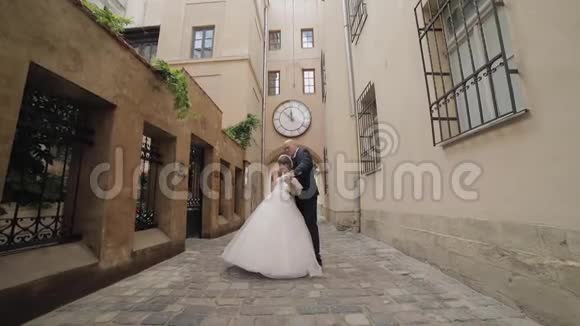 新婚夫妇在旧城的中心跳舞新郎新娘婚礼视频的预览图