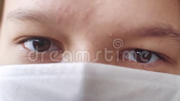 戴医疗面具的青少年眼睛的宏观镜头视频的预览图