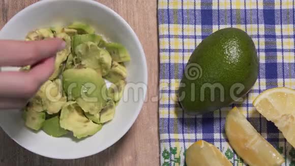 鳄梨酱配方第二步柠檬被挤入鳄梨果肉的白色盘子然后搅拌所有的东西视频的预览图