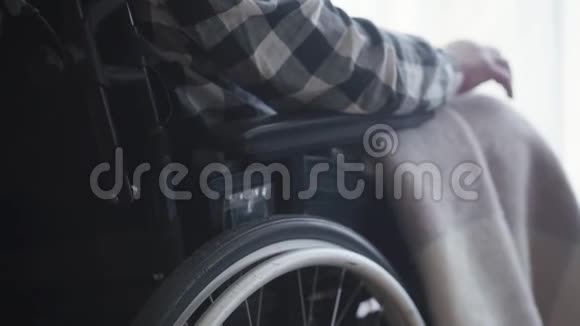 坐在轮椅上的残疾白人老人成熟的瘫痪者使用移动设备视频的预览图