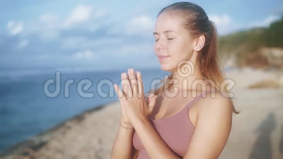 女性练习瑜伽的肖像专注于海滩呼吸慢动作视频的预览图