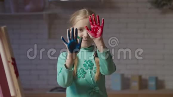 可爱的小女孩手里拿着五颜六色的颜料视频的预览图