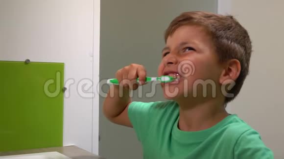 穿绿色t恤的小男孩刷牙视频的预览图