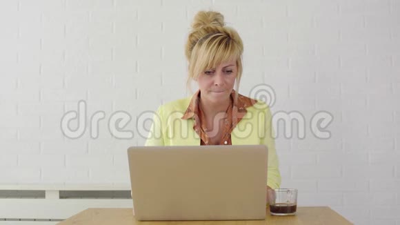 年轻的金发商务女性在使用笔记本电脑时非常沮丧和紧张视频的预览图