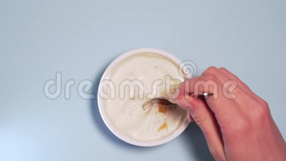一个人吃一勺无麸质素食酸奶配上新鲜水果女人的手在一个视频的预览图
