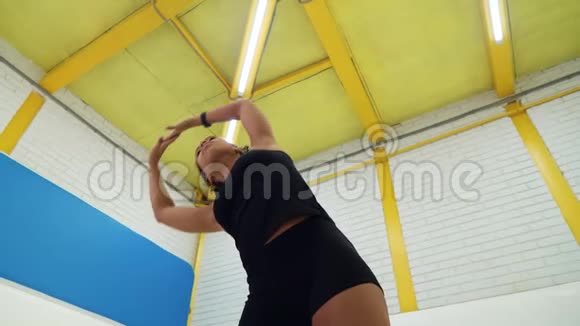 健身女孩在健身房热身伸展背部和手臂视频的预览图