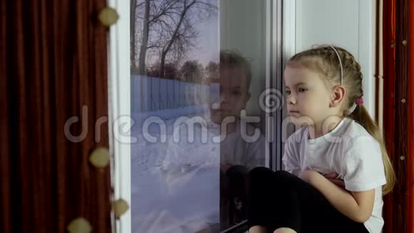 小女孩坐在窗台上望着窗外视频的预览图
