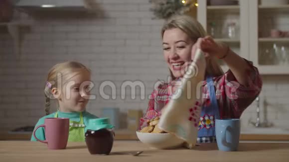 妈妈和孩子在厨房吃自制饼干视频的预览图