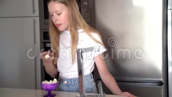 少女在厨房吃奶油甜点视频的预览图