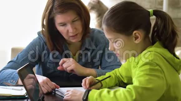 和妈妈一起在家学习的年轻学生视频的预览图