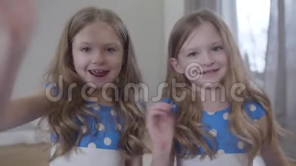 两个可爱的高加索姐妹在镜头前挥手的特写镜头一边说一边笑正面的欢乐景色视频的预览图