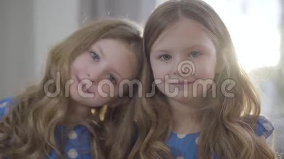 特写两个小白种人女孩在阳光下看着相机微笑一个长着棕色头发的孩子视频的预览图